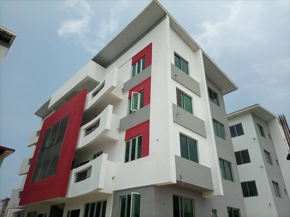 Completed contemporary apartment block, white render with coloured feature panel