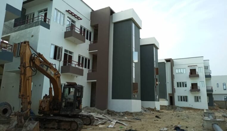 Completed estate blocks with an excavator working in front of them